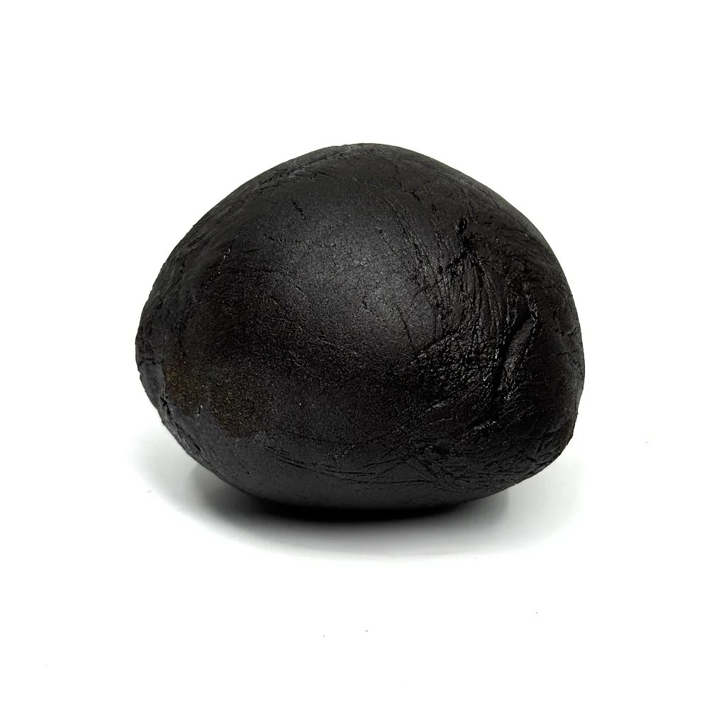 Boule noire de résine CBD Charas Limoncello, texture rugueuse, fond blanc
