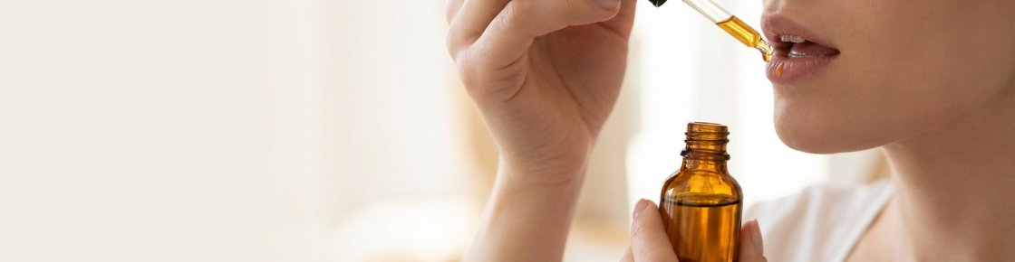 Pipette déposant des gouttes d'huile de CBD sous la langue – voie sublinguale